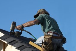 a Pearland roofer on a roof making roof repairs