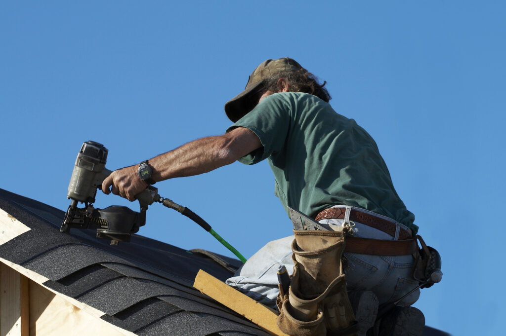 a Pearland roofer on a roof making roof repairs