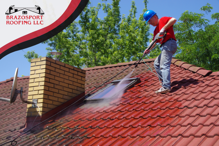 A professional soft washing technician from Brazosport Roofing applying the low-pressure cleaning solution, showcasing the safe and effective method for roof repair in Freeport.