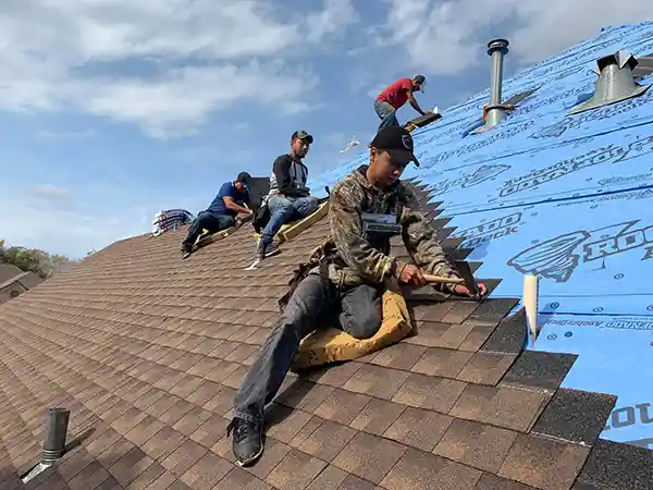 Brazosport Roofing, LLC Team installing asphalt roof shingles on a house